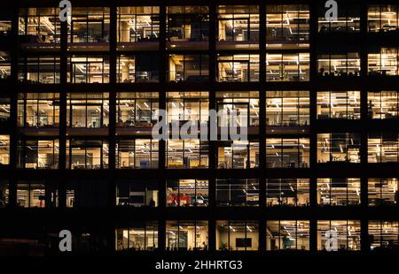Finestre di ufficio in un blocco di uffici di notte Foto Stock