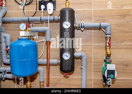 Vaso di espansione per la protezione da sovrapressione e frizione idraulica in un moderno locale caldaie a gas naturale, rivestito con piastrelle in ceramica. Foto Stock