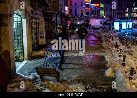 25 gennaio 2022: La neve accumulata di fronte alla strada, marciapiedi e negozio coperto di neve è stata spazzata via da operai e squadre municipali. La tanto attesa nevicata ha avuto un impatto negativo sulla vita a Istanbul. Soprattutto dopo la pesante nevicata di notte che collega il 24 gennaio al 24th, la vita nelle aree turistiche ha cominciato a tornare alla normalità. (Credit Image: © Tolga Ildun/ZUMA Press Wire) Foto Stock