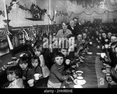 Sotto gli archi. Bambini della St Albans School, Liverpool, che hanno il loro partito di Natale nei ripari di raid aerei nel North End. I rifugi sono arcate ferroviarie e ben attrezzate con cuccette. 18th dicembre 1941. Foto Stock