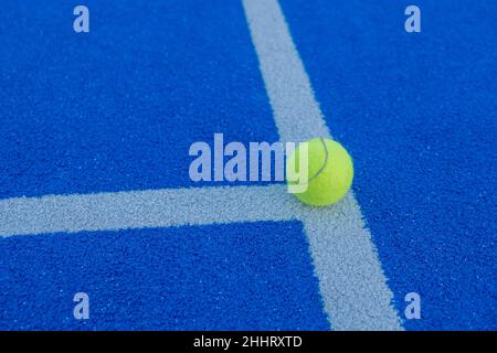 Una palla sulla linea di un campo da paddle tennis di erba sintetica blu. Concetto di salute e sport Foto Stock