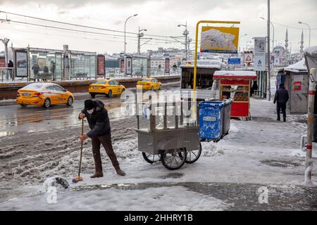 25 gennaio 2022: La neve accumulata di fronte alla strada, marciapiedi e negozio coperto di neve è stata spazzata via da operai e squadre municipali. La tanto attesa nevicata ha avuto un impatto negativo sulla vita a Istanbul. Soprattutto dopo la pesante nevicata di notte che collega il 24 gennaio al 24th, la vita nelle aree turistiche ha cominciato a tornare alla normalità. (Credit Image: © Tolga Ildun/ZUMA Press Wire) Foto Stock