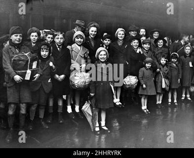 Bambini di Liverpool, evacuati dal distretto alle aree di Cardiganshire, Aberystwyth e Wrexham, raffigurati al loro arrivo a casa alla stazione di Lime Street. Molti sono andati da 5 anni. 29th novembre 1944. Foto Stock