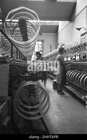 Le donne lavoratrici scherzano mentre sorvegliano la filatura del cotone, Miklan, Italia. Circa 1955 Foto Stock