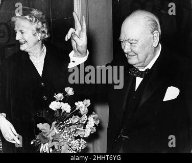 Il primo ministro britannico Winston Churchill dà il famoso V Sign mentre si trova in piedi con Lady Churchill al numero 10 Downing Street dopo la sua cerimonia di compleanno del 80th a Westminster Hall.30th novembre 1954. Foto Stock