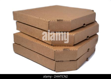 Accatastare le scatole di cartone marrone piatto per pizza isolate su uno sfondo bianco, snack leggero. Foto Stock