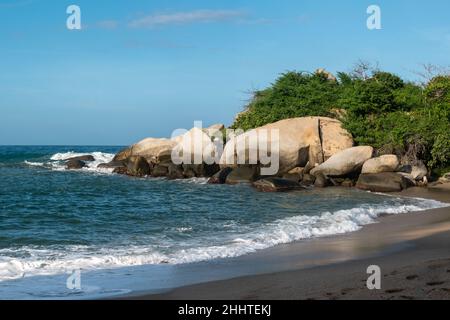 Paesaggio delle onde del mare che si avvicina fortemente alla riva con un lotto di schiuma nel Parco Tayrona, Colombia Foto Stock