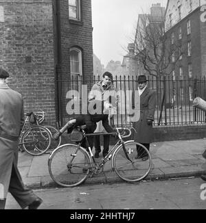 Padre guarda suo figlio provare i cicli per la vendita al mercato delle pulci in Club Row, Bethnal Green, E1 Londra 1st marzo 1955 Foto Stock