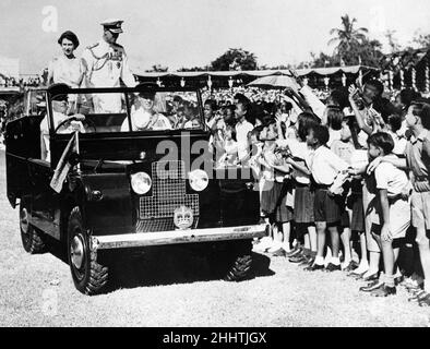 La Regina Elisabetta II e il Principe Filippo sorridono a far vacillare i bambini durante la visita degli eredi al raduno dei bambini al Sabina Park di Kingston, Giamaica durante il Royal Tour del Commonwealth 26th novembre 1953. Foto Stock