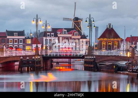 Night Leiden canale con Blauwpoortsbrug ponte e Windmill De Valk, South Holland, Paesi Bassi. Foto Stock