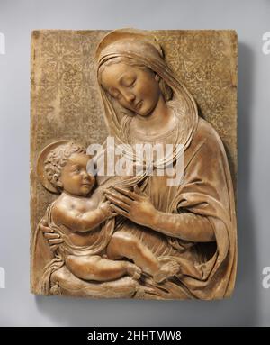 Madonna col Bambino ca. 1490 Benedetto da Maiano italiano questa Madonna col Bambino è l'ultima di una serie di rilievi quattrocenteschi nel Museo di alcuni dei più importanti scultori fiorentini. Nella sua scelta del soggetto e nel suo trattamento, Benedetto da Maiano seguì il suo maestro Antonio Rossellino (vedi acc. n. 14.40.675) e il suo connazionale e quasi contemporaneo desiderio da Settignano, ma il contributo di Benedetto a questo punto dell'arte italiana, opera tardiva dell'artista, ha una particolare solidità e monumentalità. La Vergine è fortemente rivestita in una tunica a manica lunga con un mantello o Foto Stock