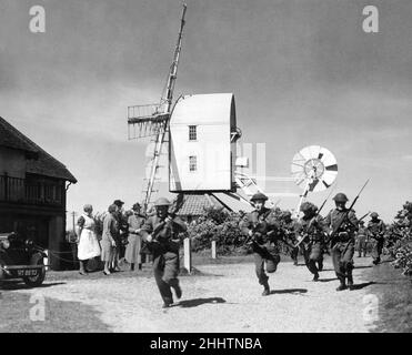 I volontari della Home Guard si allenano nel villaggio Suffolk di Thorpeness mentre i residenti guardano sopra durante la seconda guerra mondiale. 16th maggio 1943. Foto Stock