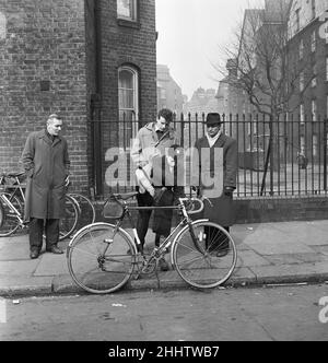 Padre guarda suo figlio provare i cicli per la vendita al mercato delle pulci in Club Row, Bethnal Green, E1 Londra 1st marzo 1955 Foto Stock