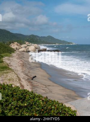 Paesaggio delle onde del mare che si avvicina fortemente alla riva con un lotto di schiuma nel Parco Tayrona, Colombia Foto Stock