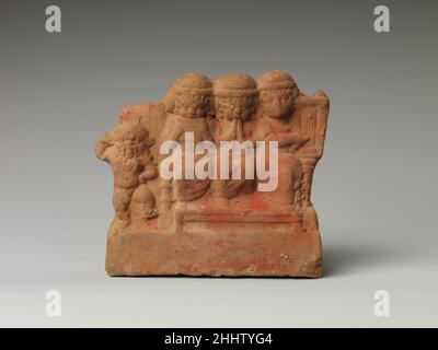 Bes danzante insieme a un gruppo di musicisti seduti 332–30 a.C. periodo tolemaico questa elaborata terracotta raffigura Bes danzante insieme a un trio di musicisti seduti su una panchina. Tra i musicisti figurano un sirinx (Pan-Pipe), un doppio flauto e un lire con un plectrum. Indossano indumenti lunghi e capelli ricci lunghi sulle spalle sui quali tirano cappucci rotondi con brims piegati. La panca ha elaborato braccioli scolpiti e un lungo sgabello. Ballando Bes insieme a un gruppo di musicisti seduti 551321 Foto Stock