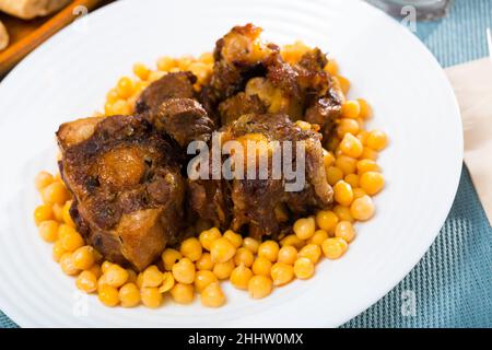 Brasati oxtails con ceci su una piastra bianca Foto Stock