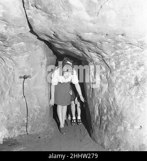 Il pubblico di uno spettacolo dei Pirati di Penzance si rivolge alla zona di spettacolo nelle grotte nelle scogliere sopra la città di mare Sussex di Hastings. 16th ottobre 1946 Foto Stock