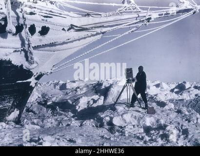 L'epica spedizione antartica di Ernest Shackleton del 1914-1917, in cui la loro nave Endurance fu schiacciata dal ghiaccio. Qui il fotografo Frank Hurley è sul ghiaccio dalle inchioni di Endurance con la sua macchina fotografica. Foto Stock