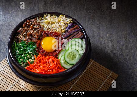 Piatto di riso in stile coreano Bibimbap. Ciotola di riso bianco caldo con bubuggi di manzo, verdure saltate e condite Foto Stock