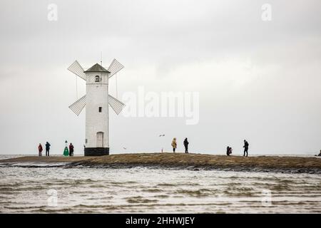 Swinoujscie, Polonia. 17th Nov 2021. La gente ha visto camminare intorno al faro di Stawa Mlyny, situato all'ingresso del porto di Swinoujscie. Un faro bianco a forma di mulino a vento è un simbolo di Swinoujscie ed è parte del logo ufficiale della città. Il Porto di Swinoujscie è un porto marittimo polacco sul Mar Baltico. Insieme al porto di Szczecin, crea uno dei più grandi complessi portuali del Mar Baltico. (Foto di Karol Serewis/SOPA Images/Sipa USA) Credit: Sipa USA/Alamy Live News Foto Stock