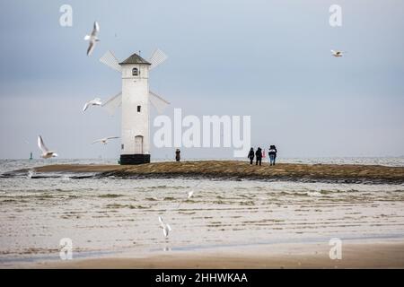 Swinoujscie, Polonia. 17th Nov 2021. La gente ha visto camminare intorno al faro di Stawa Mlyny, situato all'entrata del porto di Swinoujscie.Un faro bianco nella forma di un mulino a vento è un simbolo di Swinoujscie ed è una parte del logo ufficiale della città. Il Porto di Swinoujscie è un porto marittimo polacco sul Mar Baltico. Insieme al porto di Szczecin, crea uno dei più grandi complessi portuali del Mar Baltico. (Credit Image: © Karol Serewis/SOPA Images via ZUMA Press Wire) Foto Stock