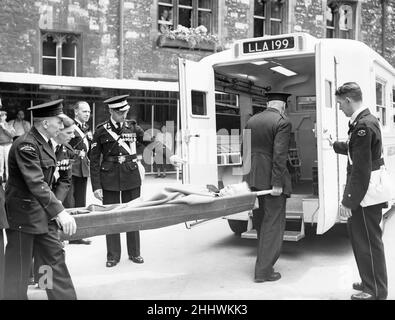 Coronation 1953 prova di vestito completo a Westminster Abbey, Londra, venerdì 29th maggio 1953. La nostra foto mostra ... uno degli araldi dell'incoronazione, il LionKing of Arms, Sir Thomas Innes, che è crollato al vestito prova, è eseguito su una barella, e portato da ambulanza al suo hotel di Londra. Sir Thomas 59, precederà il Duca di Edimburgo nella processione di martedì. Foto Stock