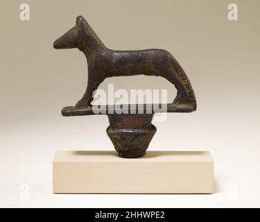 Jackal standard 664–30 a.C. periodo tardo-periodo tolemaico la divinità canina Wepwawet si erge sulla parte superiore di un papyriform standard; è attento e attento con le orecchie pricked in avanti. Wepwawet era conosciuto come il 'apritore delle vie' e sui rilievi e stele del tempio, tali standard sono stati spesso portati in processioni e festival. in questo periodo il dio era associato principalmente a Osiride e alle sue pratiche di culto. Osiride era molto popolare nei periodi tardo e tolemaico come una dedica e la rappresentazione frequente degli standard di Wepwawet in lega di rame può essere legata a tha Foto Stock