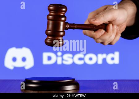 Gavel in mano sullo sfondo del logo della piattaforma di gioco sociale Discordia. Il concetto della prova. Foto Stock