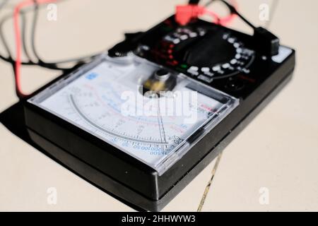 Apparecchiatura di misurazione con multimetro analogico per il controllo della tensione di amperaggio sugli interruttori automatici e sui sistemi di cablaggio sulle schede di distribuzione dell'alimentazione principale. Foto Stock