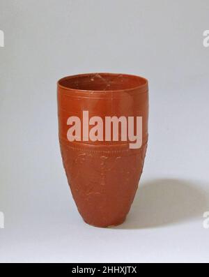 Becher in terracotta ca. A.D. 10–15 Roman questo grande becher è attribuito al laboratorio di CN. Ateius, uno dei migliori produttori di ceramiche arretine romane nel tardo periodo augusteo. Anche se tali oggetti stampati in rilievo e di colore rosso-lucido sono stati prodotti in serie per il mercato generale, spesso contenevano caratteristiche che richiamano gli esempi più alti di arte romana. Il supporto ornato e i motivi di cigno su questo becher richiamano elementi nei dipinti murali dalla villa di lusso a Boscotrecase, Come visto nella Sala Nera adiacente a questa galleria. Bicchiere in terracotta. Romana. CA. A.D. 10–15. Terracotta; Arretine. Presto Foto Stock