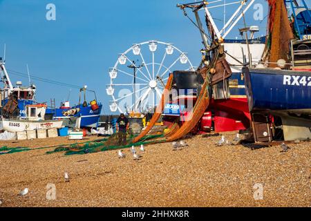 Reti di cernita dei pescatori di Hastings sul vecchio Stade della città Spiaggia di pesca della barca, Sussex orientale, Regno Unito Foto Stock