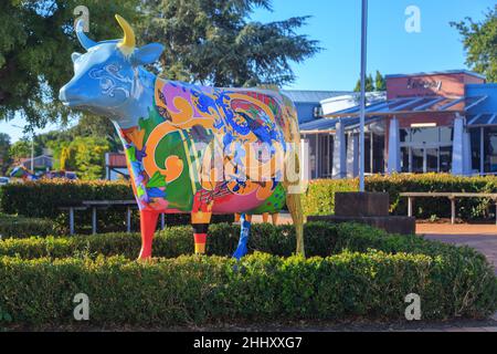 Morrinsville, Nuova Zelanda. 'Kiwiana', una delle numerose sculture di mucche della città, fuori dalla biblioteca di Morrinsville Foto Stock