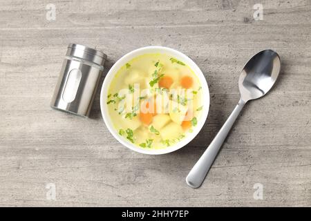 Zuppa di pollo su sfondo grigio testurizzato, vista dall'alto Foto Stock