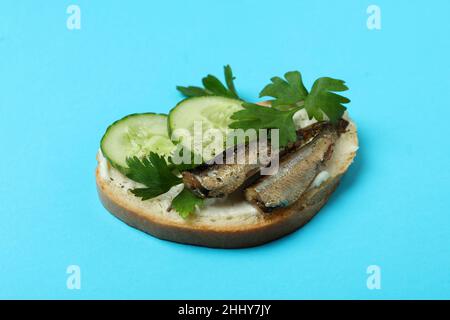 Gustoso sandwich con spratti su sfondo blu Foto Stock