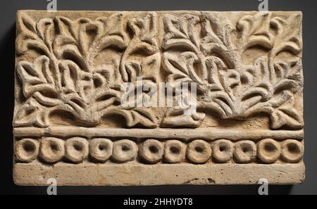 Decorazione a parete con disegno vegetale ca. 6th secolo d.C. i rilievi Sasanian Stucco sono stati comunemente usati per decorare gli iwans e le sale di ricezione delle case Sasanian d'elite. Molti esempi sono stati trovati nelle case scavate nell'area di Ctesifon compreso questo rilievo da Ma'aridh IV costituito da due piante stilizzate sopra un bordo bordato. L'uso di stampi per la realizzazione di stucchi ha consentito la creazione di modelli ripetitivi su larga scala come motivi floreali e vegetali. Questo modello si trova anche nella vicina casa di Ma'aridh VI, indicando il riutilizzo degli stampi per creare stucchi per diversi edifici. Foto Stock
