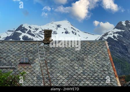 TAFJORD, NORVEGIA - 2020 GIUGNO 01. Vecchio tetto rustico in ardesia con montagna ghiacciaio sullo sfondo. Foto Stock