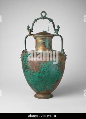 Bronzo collo-anfora (vaso) con coperchio e manico della barra ultimo quarto del 6th secolo a.C. vasi di metallo greco sono molto più rari delle loro controparti in ceramica perché meno sono stati fatti e perché il metallo si è deteriorato o è stato fuso giù. Sono note solo circa mezza dozzina di anfore di bronzo complete. Le maniglie laterali servivano per il versamento, la staffa oscillante per il sollevamento e il trasporto. L'abbellimento qui è particolarmente magistrale: Non solo la testa del Gorgone sotto le maniglie ma anche la bordatura, le lingue, e le gemme di lotos sul piede, sul labbro e sulle maniglie. Collo di bronzo-anfora (vaso) con coperchio e manico Foto Stock