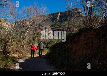 Coppie anziane passeggiate all'aperto trekking nel paesaggio catalano montagne e prati a Sant Miquel del Fai nella campagna della Catalogna. Catalano rurale Foto Stock