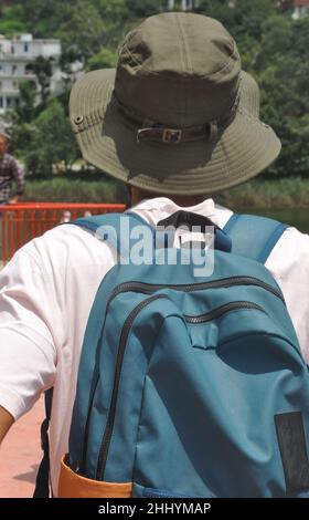 Vista posteriore di un turista maschile con zaino che cammina fuori Foto Stock