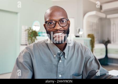 La buona salute degli occhi mi rende felice. Ritratto di un giovane uomo sicuro che lavora in un ufficio optometristi. Foto Stock