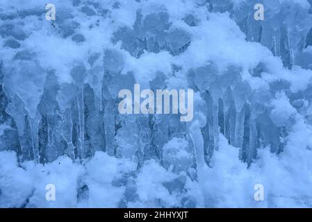 Dettagli di neve e stalattiti di ghiaccio nella cascata Salt de Murcurols ghiacciata e nevosa in inverno (Berguedà, Catalogna, Spagna, Pirenei) Foto Stock