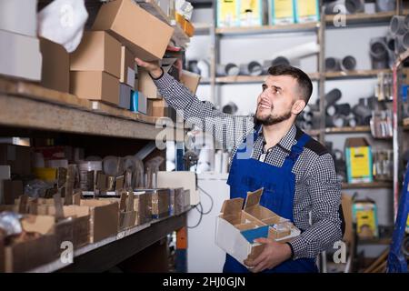 Uomo adulto lavoratore cernita dati tecnici sanitari Foto Stock