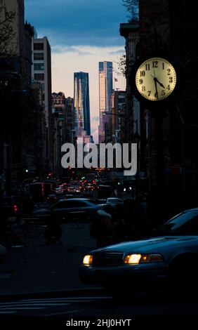 Faszinierender Kontrast zwischen den dunklen Gassen Manhattans und zwei Hochhäusern im Abendlicht Foto Stock
