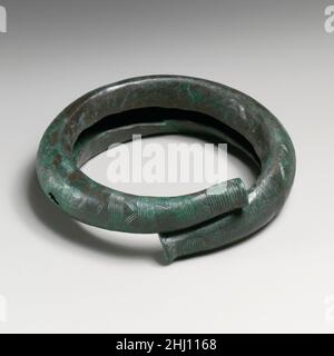 Bracciale in bronzo del 8th secolo a.C. Italico, eventualmente Dauniano decorato con una serie di linee raggruppate verticali e diagnostiche incise. Bracciale in bronzo. Italic, forse Daunian. 8th secolo a.C. Bronzo. Geometrico. Bronzi Foto Stock