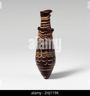 Alabastron di vetro (bottiglia di profumo) 2nd–metà 1st secolo a.C. Greco, Mediterraneo orientale traslucido viola profondo, con striature più chiare e rossastre; maniglie in blu scuro traslucido; tracce in bianco opaco e un altro in colore ormai indeterminato.disco bordo quasi orizzontale; collo cilindrico; corpo fusiforme diritto che si espande verso il basso, quindi rastremandosi verso il fondo appuntito; Due maniglie di aletta orizzontali applicate sopra la pista in cima al corpo, uno leggermente più alto dell'altro.tracce attaccate in basso, disegnate in una spirale al punto di carinazione, utensili in un modello di festone con tredici st ascendente Foto Stock