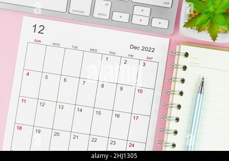 Il calendario del dicembre 2022 con tastiera su sfondo rosa. Foto Stock