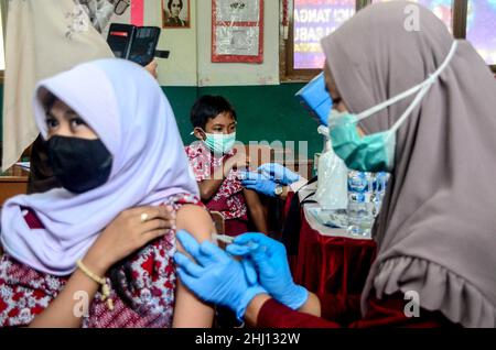 Bogor, Indonesia. 26th Jan 2022. Un operatore sanitario somministra una dose di vaccino COVID-19 a un bambino durante la vaccinazione per i bambini di età compresa tra 6 e 11 anni a Bogor, West Java, Indonesia, 26 gennaio 2022. Credit: Sandika Fadilah/Xinhua/Alamy Live News Foto Stock