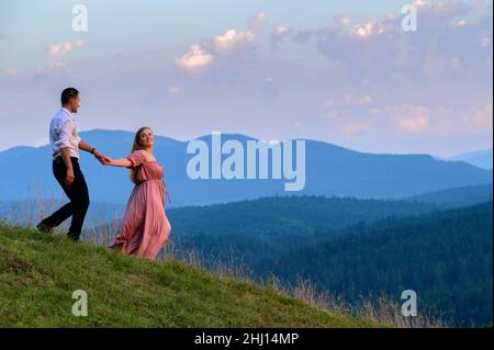 Vorokhta, Ucraina 28 luglio 2021:un ragazzo con una ragazza che cammina nei prati di montagna, pittoreschi e misteriosi Carpazi ucraini, le cime dei Carpazi Foto Stock