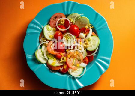 Goiania, Goias, Brasile – 25 gennaio 2021: Un piatto di insalata di verdure su sfondo arancione. Foto Stock