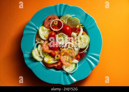 Goiania, Goias, Brasile – 25 gennaio 2021: Un piatto di insalata di verdure su sfondo arancione. Foto Stock